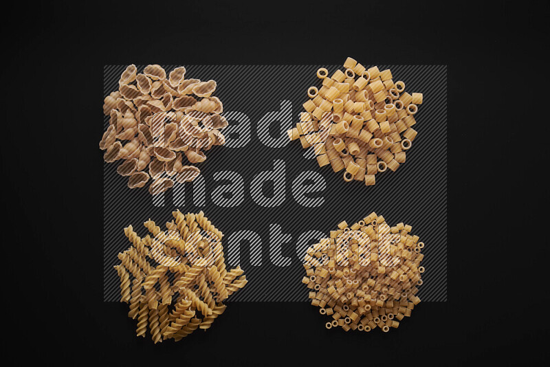 Different pasta types in bunches on black background