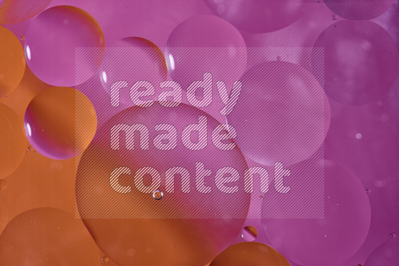 لقطات مقربة لفقاعات من الزيت على سطح الماء باللون البرتقالي والوردي