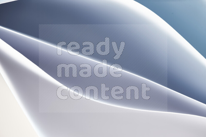 هذه الصورة تعرض تكوين فن الورق التجريدي مع منحنيات ورقية بتدرجات اللون الأزرق والأبيض المكونه بواسطة الضوء الملون