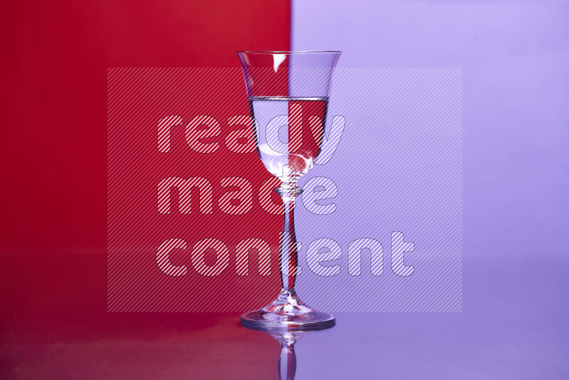 The image features a clear glassware filled with water, set against red and light purple background