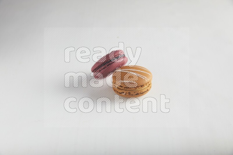 45º Shot of of two assorted Brown Irish Cream, and Red Cherry macarons on white background