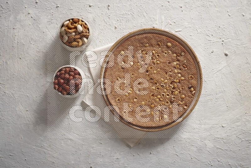 بسبوسة مع المكسرات علي خلفية بيضاء خشبية