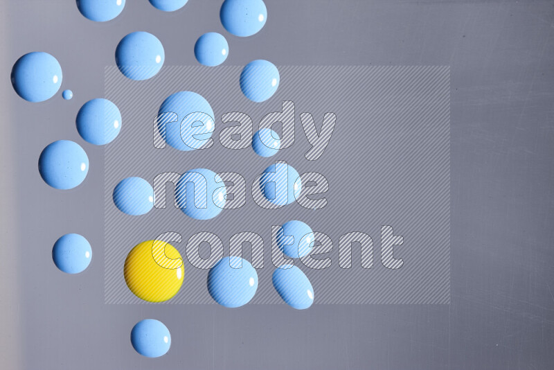 Close-ups of abstract blue and yellow paint droplets on the surface