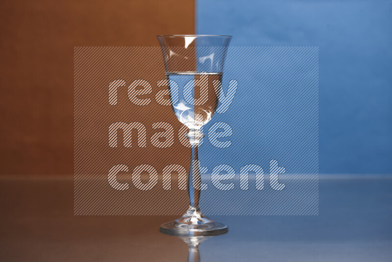 The image features a clear glassware filled with water, set against brown and blue background