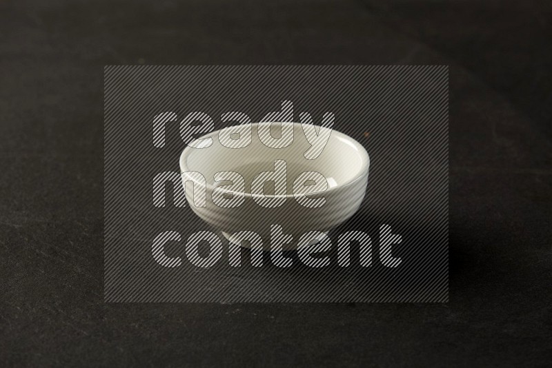 white ceramic round sauce bowl on grey textured countertop