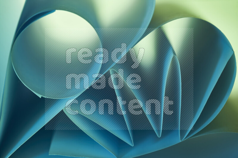 عرض فني لطيات الورق تخلق مزيج من الأشكال الهندسية، مضاءة بإضاءة ناعمة بدرجات اللون الأخضر والأزرق