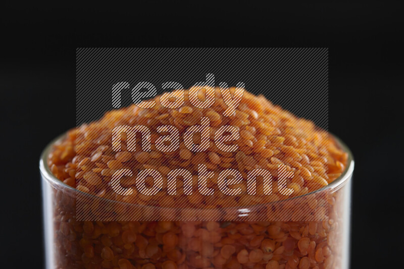 Lentils in a glass jar on black background