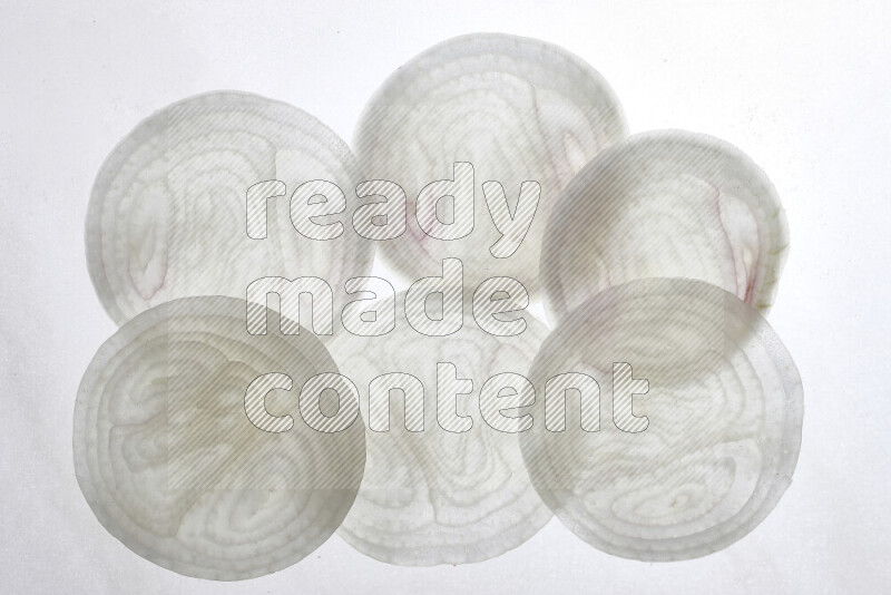 Onion slices on illuminated white background