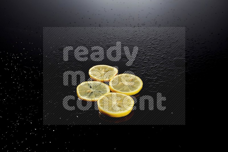 Lemon slices with water drops, and droplets on black background