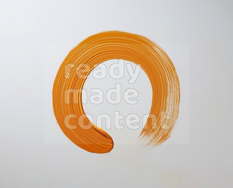 An orange circular painting brush stroke on white background