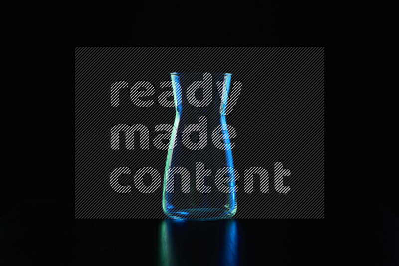 Glassware with rim light in blue and green against black background