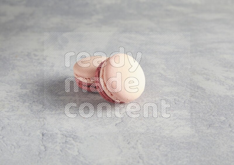 45º Shot of two Pink Litchi Raspberry macarons  on white  marble background