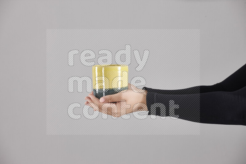 A woman in black abaya holding different pottery essentials in different positions