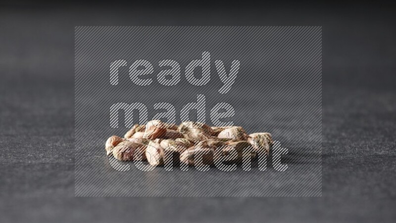 A bunch of peeled pistachios on a black background in different angles