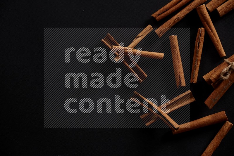 Cinnamon sticks stacked on black flooring