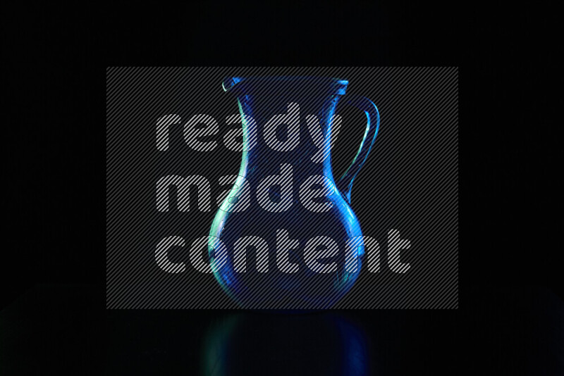 Glassware with rim light in blue and green against black background