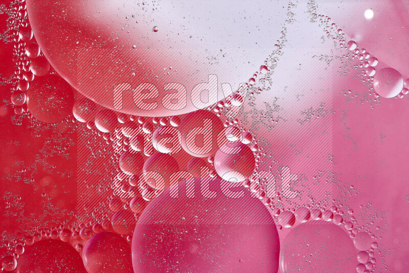 Close-ups of abstract oil bubbles on water surface in shades of white, red and pink