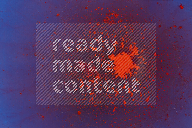 تلتقط الصورة تناثرا للطلاء الأحمر علي خلفية زرقاء