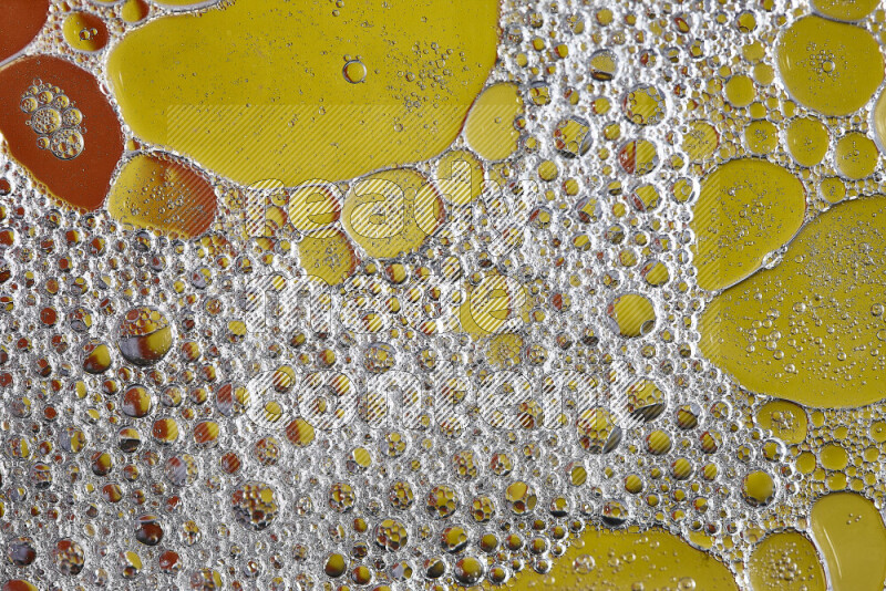 Close-ups of abstract soap bubbles and water droplets on orange and yellow background