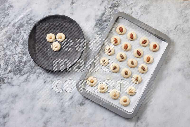 غريبة خطوة بخطوة بالمكونات الدقيق والسكر البودرة والسمن والمكسرات على خلفية رخام رمادي