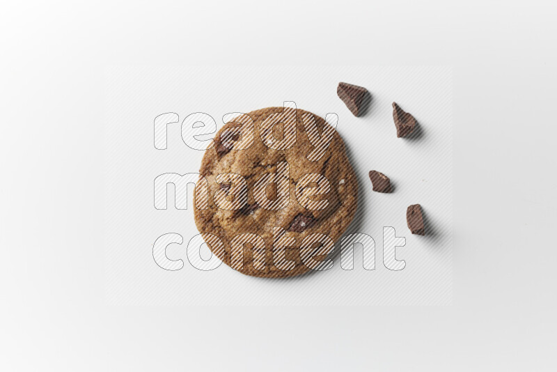 A single chocolate chips cookie with chocolate beside it on a white background