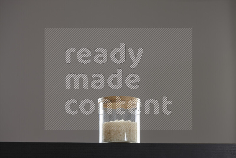 White rice in a glass jar on black background