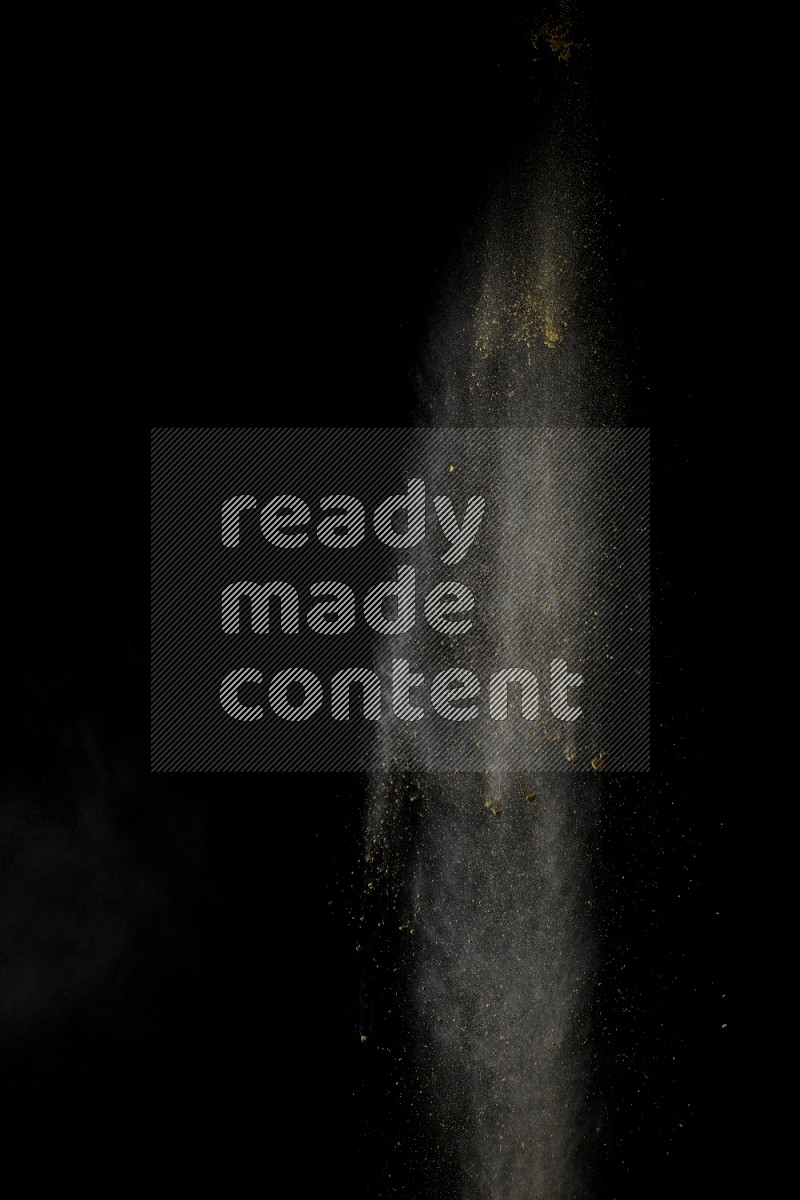 A side view of yellow powder explosion on black background