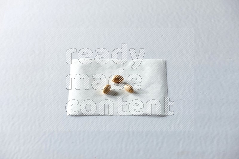 3 peeled peanuts on a piece of paper on a white background in different angles