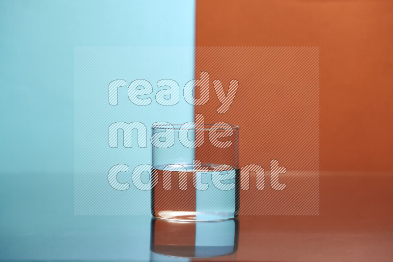 The image features a clear glassware filled with water, set against light blue and dark orange background