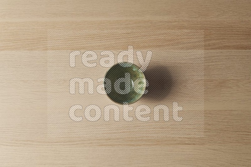 Top View Shot Of A Dark Green Pottery Bowl on Oak Wooden Flooring