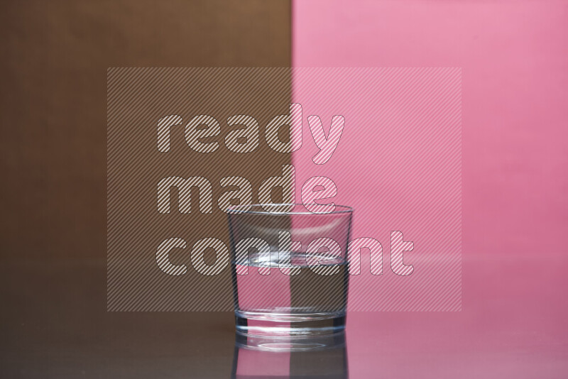 The image features a clear glassware filled with water, set against brown and pink background