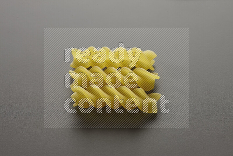 Fusilli pasta on grey background