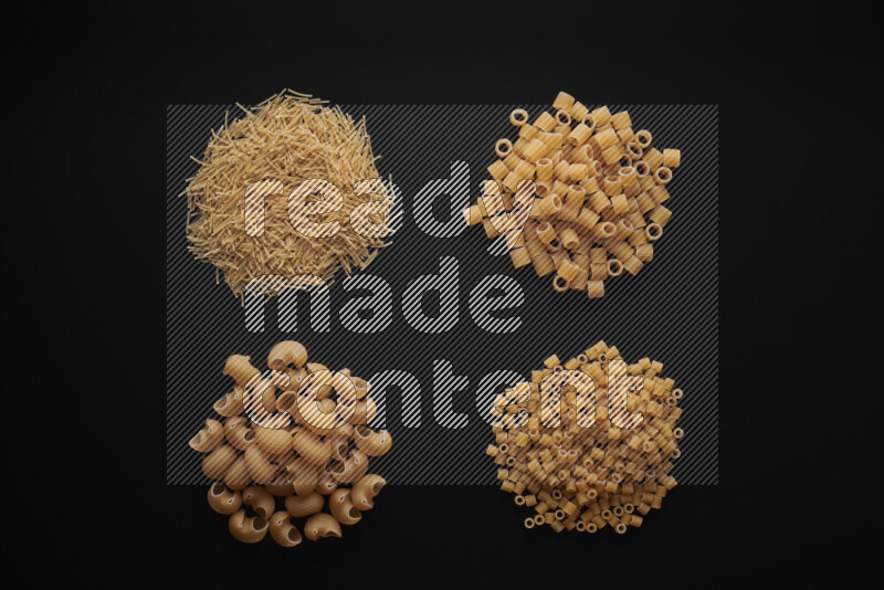 Different pasta types in bunches on black background