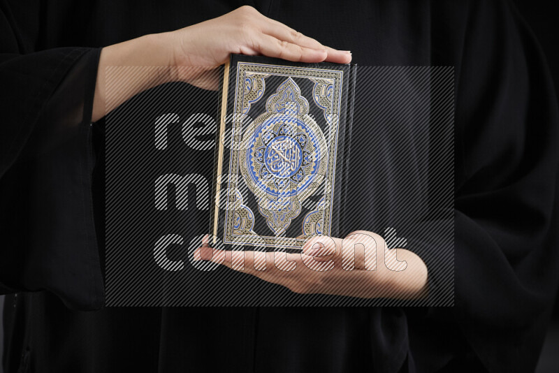 A woman hands holding moshaf in different positions