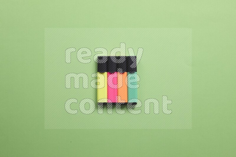 Multicolored highlighter pens on green background