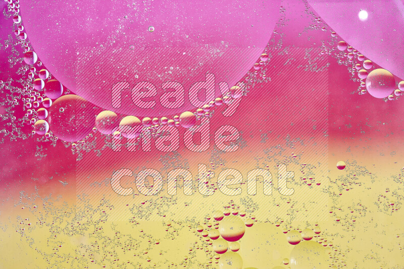 لقطات مقربة لفقاعات من الزيت على سطح الماء باللون الأصفر والوردي