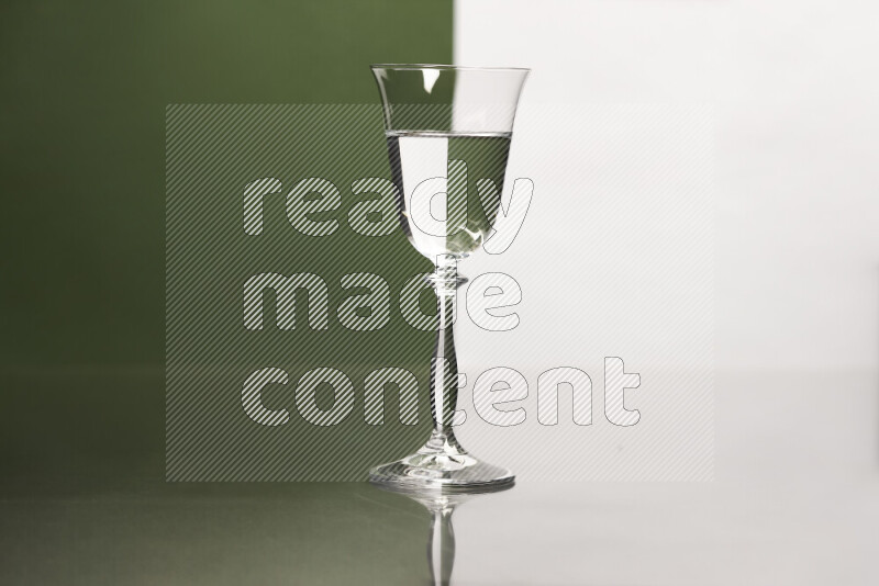 The image features a clear glassware filled with water, set against white and dark green background