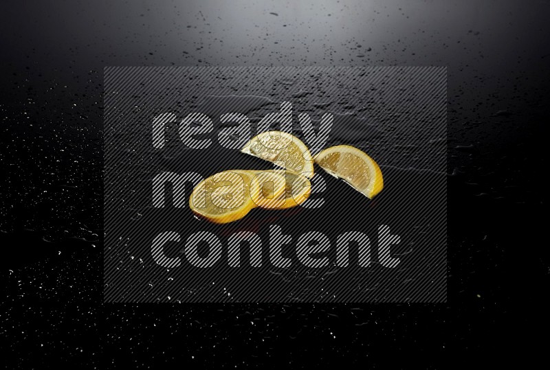 Lemon slices with water drops, and droplets on black background