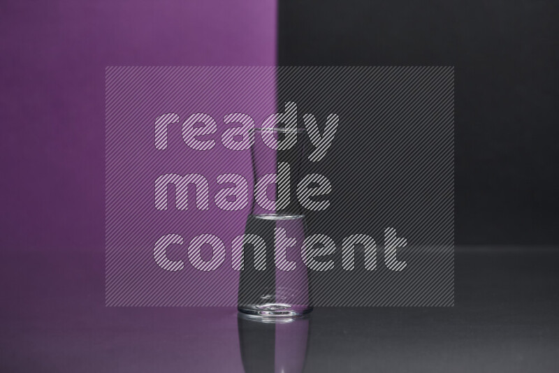 The image features a clear glassware filled with water, set against purple and black background