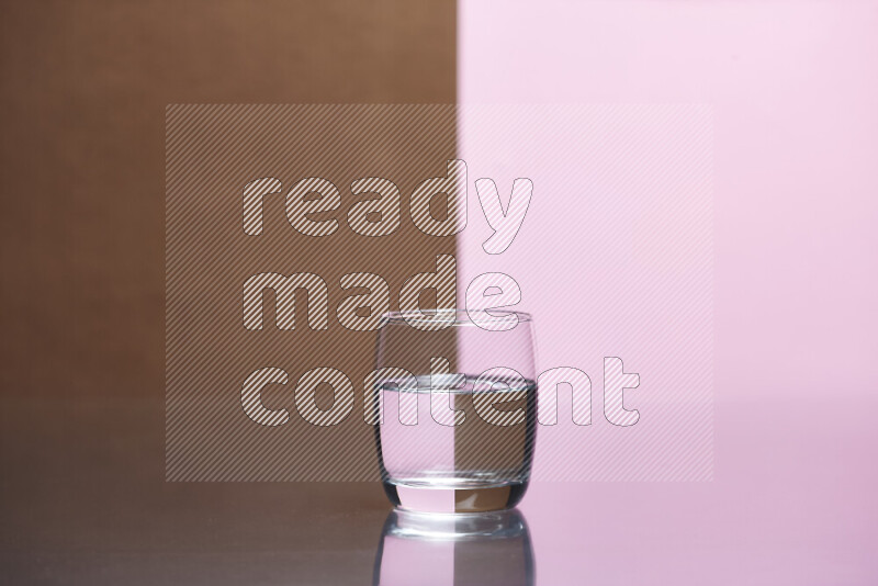 The image features a clear glassware filled with water, set against brown and rose background