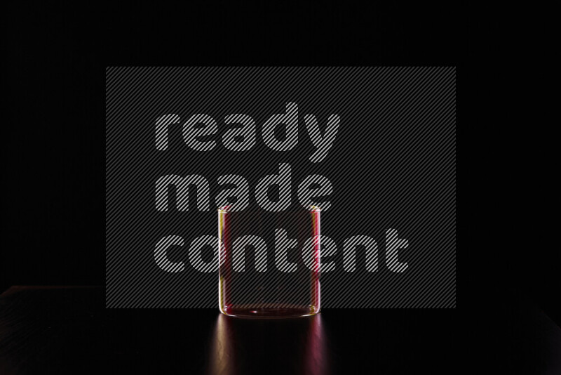 Glassware with rim light in red and yellow against black background