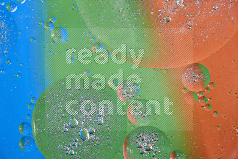 Close-ups of abstract oil bubbles on water surface in shades of orange, green and blue