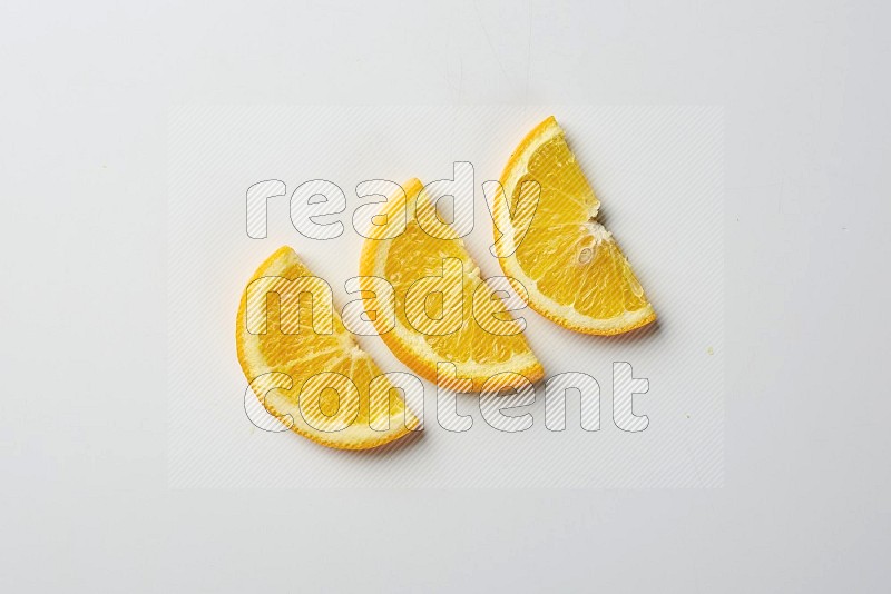 Three halves of an orange slices on white background