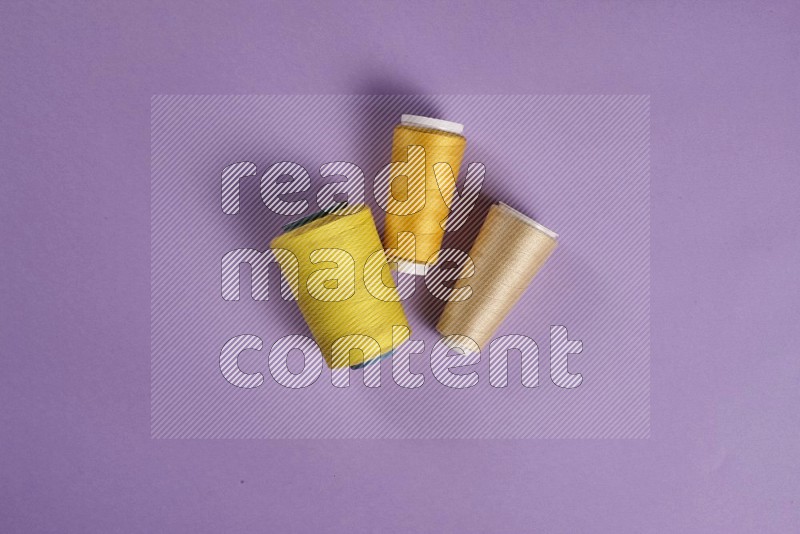 Yellow sewing supplies on purple background