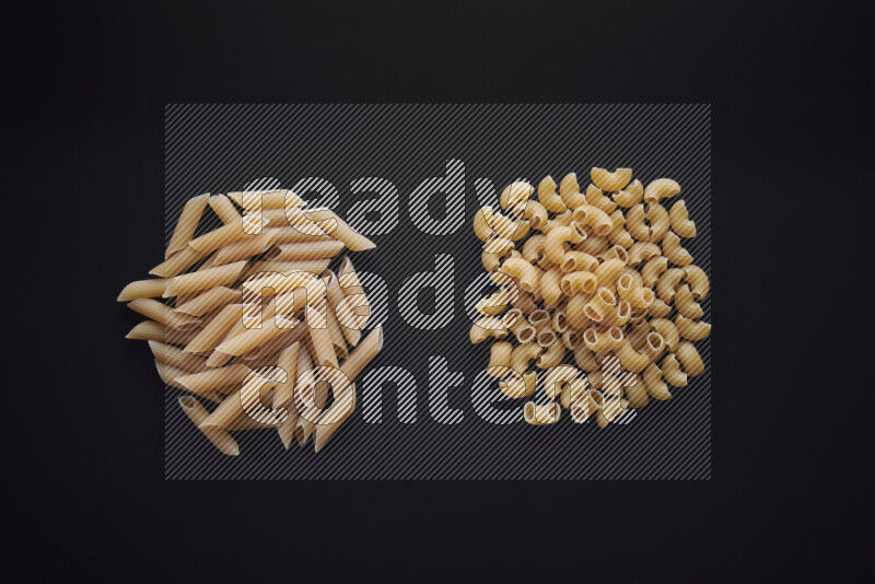 Different pasta types in bunches on black background
