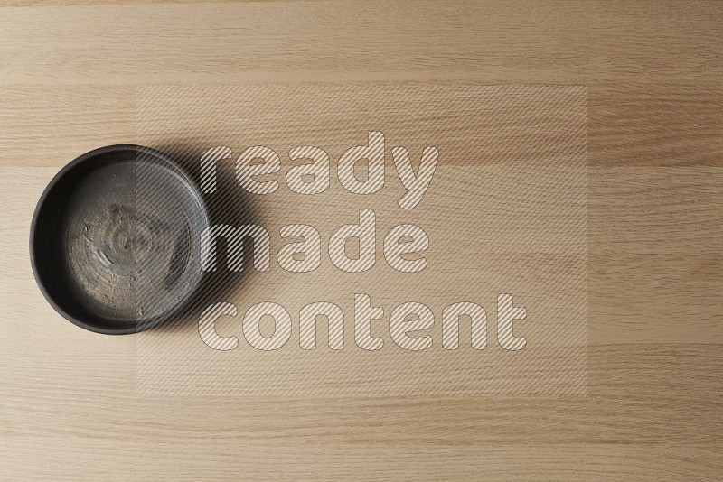 Top View Shot Of A Black Pottery Oven Plate on Oak Wooden Flooring