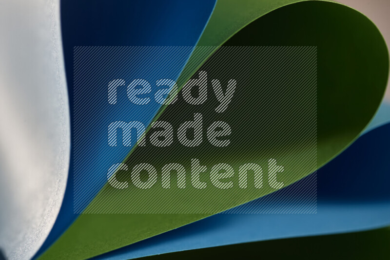 An abstract art showing blue and green paper sheets arranged in an overlapping curves