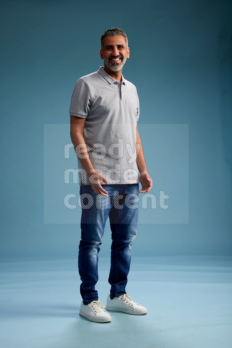 Man Standing Interacting with the camera on blue background