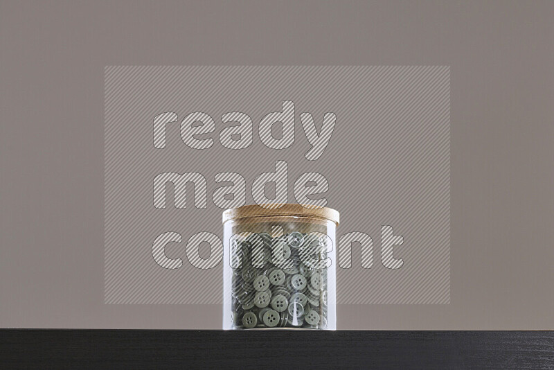 Buttons in a glass jar on black background