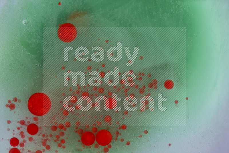 The image captures a dramatic splatter of red paint over a green backdrop